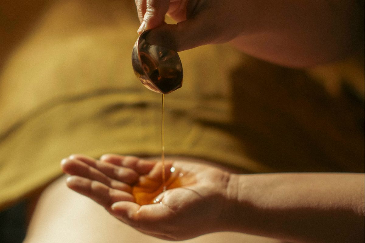 woman pouring oil into hand to perform abhyanga self massage