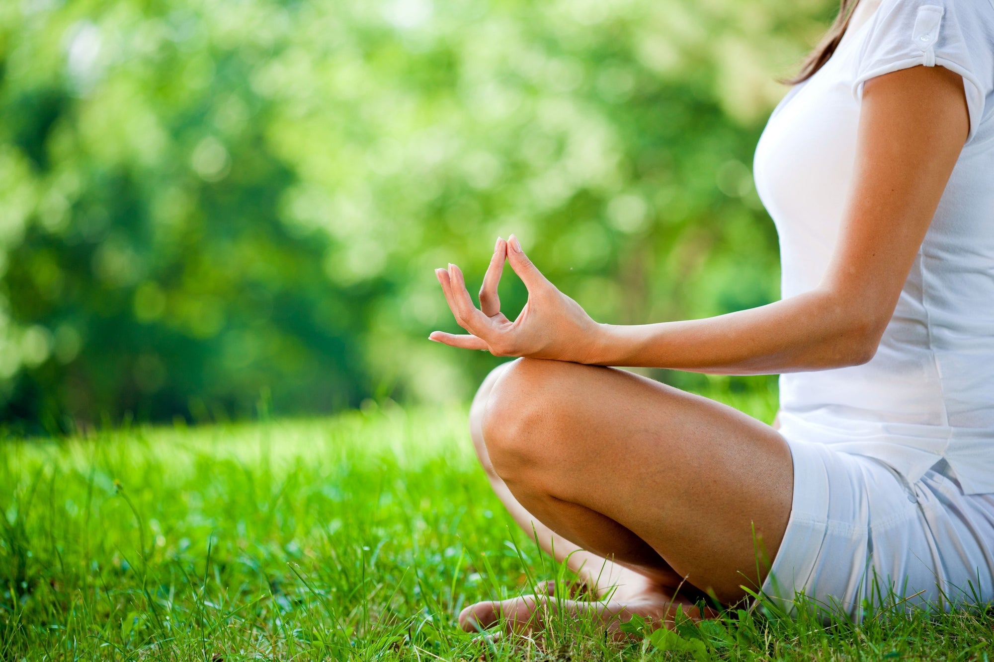 woman meditating on grass