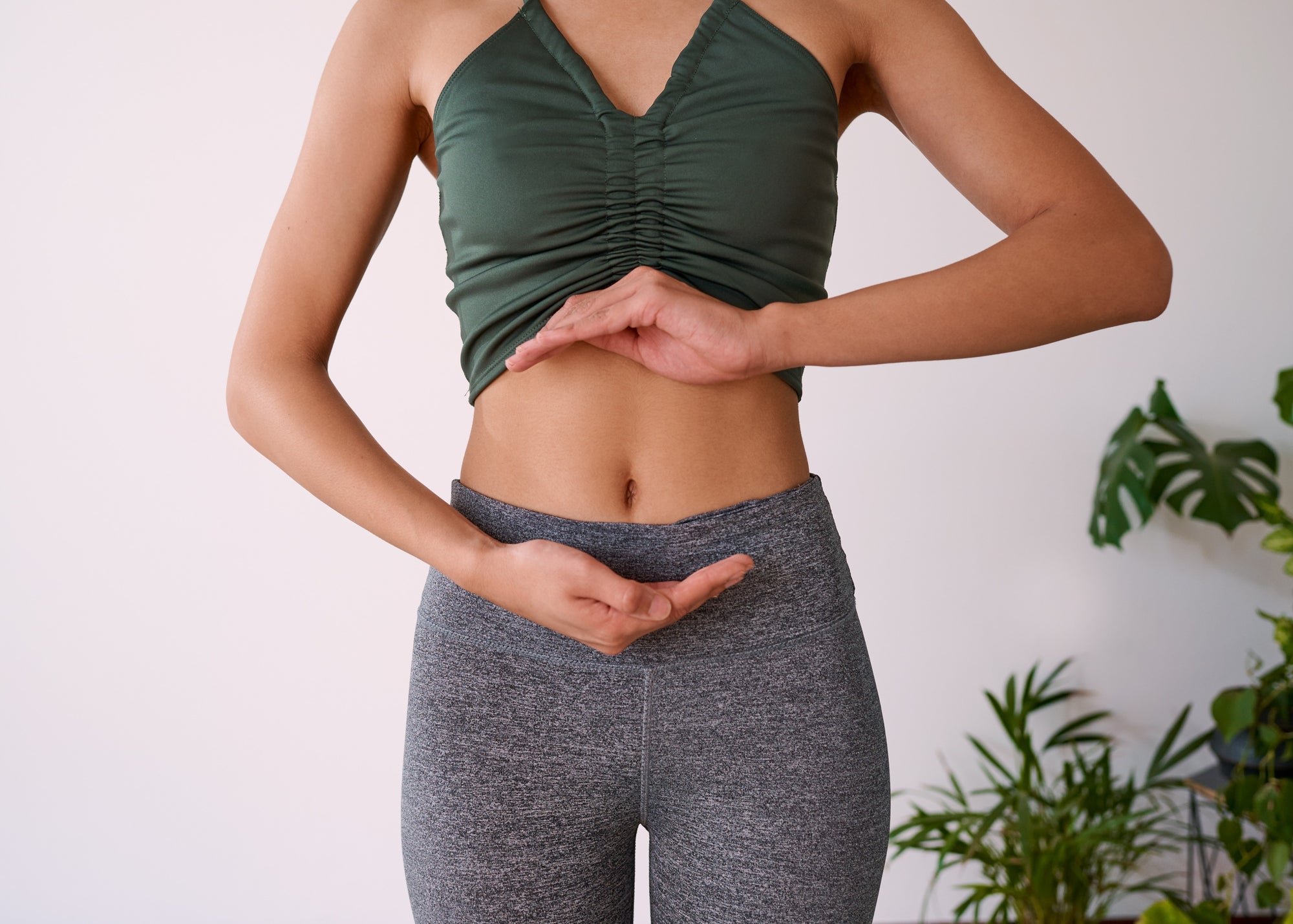 woman placing her hands around her stomach or her digestive system