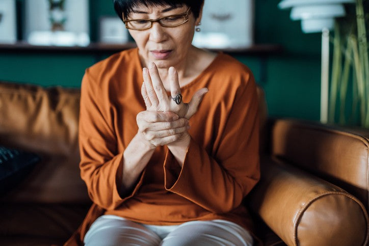 woman holding her hand in pain due to arthritis joint pains