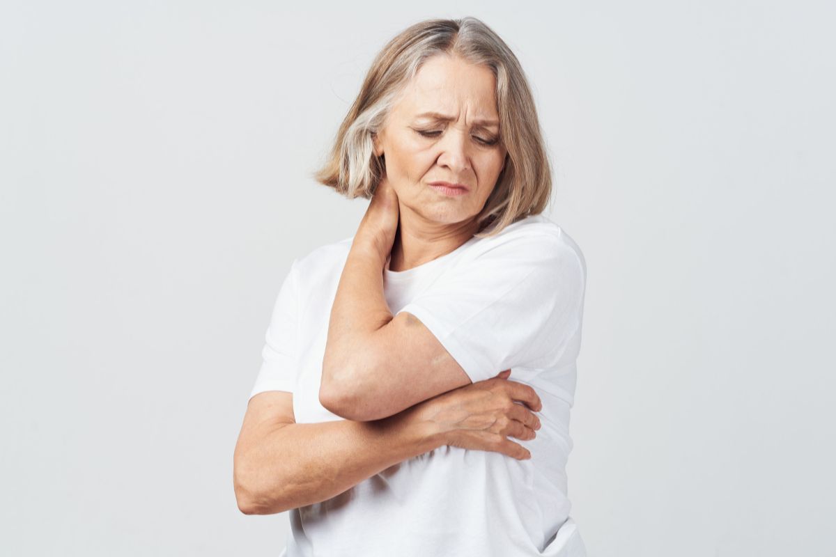 Woman uncomfortably holding her neck