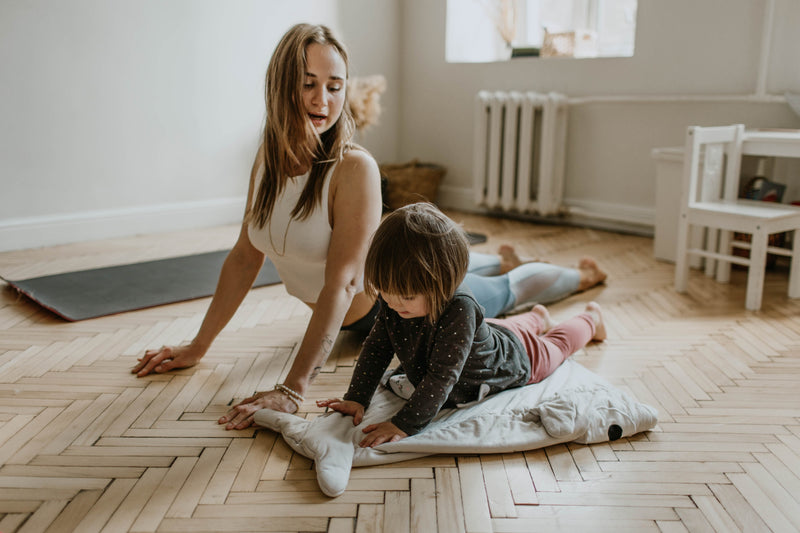 mother and child doing yoga together in lounge